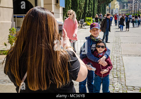 Une maman prend une photo de son jeune fils à l'aide d'un smartphone. Banque D'Images