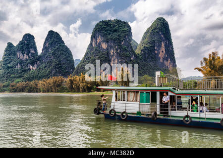 Un bateau de tourisme transporte des passagers le long de la rivière Li, Yanshuo, Chine. Elles donnent à la formation inhabituelle de la montagnes karstiques. Banque D'Images