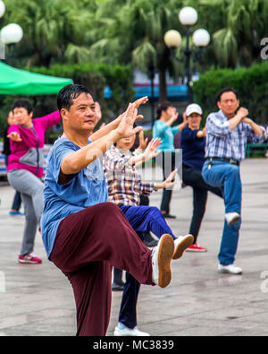 Un groupe d'hommes et femmes chinois pratiquer le Tai Chi sur une place publique, Guilin, Chine. Banque D'Images