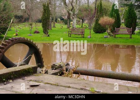 Comtesse Weir Mill Leat, Vanne Victorien et Exeter & Devon du crématorium de jardins. Exe rivière en crue. UK. Avril, 2018. Banque D'Images