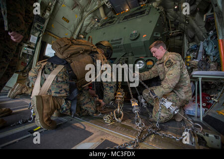 Les cadres supérieurs de l'Armée de l'air Airman Brandon Lowe (droite), arrimeur avec le 9e Escadron d'opérations spéciales, et le sergent du Corps des Marines. Jeffery Hale (à gauche), un lanceur chef avec Kilo Batterie, 2e Bataillon, 14e Régiment de Marines, vers le bas de la chaîne d'un Marine Corps un M142 Système de roquettes d'artillerie à grande mobilité (HIMARS) sur une armée de l'air MC-130 à Fort Campbell, Kentucky, le 29 mars 2018. Les Marines du kilo de batterie Fort Campbell à Dugway Proving Grounds, Utah, où ils ont débarqué et a tiré quatre missiles HIMARS, démontrant une capacité unique qui permettra aux commandants plus d'options pour faire face aux menaces lorsqu'oth Banque D'Images