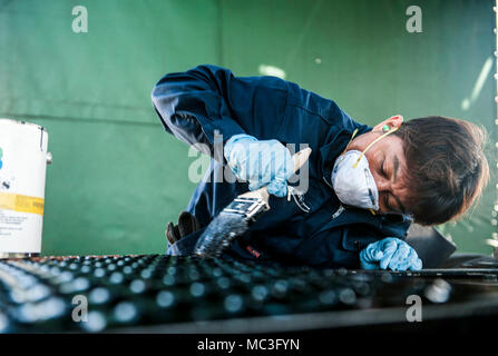 Hiroshi Kyan, 18e Escadron de préparation logistique technicien en réparation de dommages de l'aérodrome, applique une sous-couche de protection sur une remorque, le 3 avril 2018, à Kadena Air Base, au Japon. Sous-couche s'appliquent aux membres de protéger les véhicules affectés à Kadena de rouille. Banque D'Images