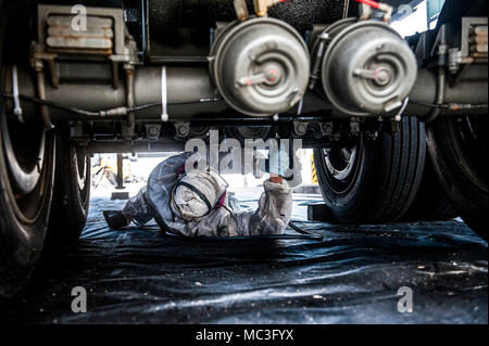 Masakazu Miyazato, 18e Escadron de préparation logistique technicien de réparation carrosserie, applique une sous-couche de protection sur une remorque, le 3 avril 2018, à Kadena Air Base, au Japon. La 18e RL gère la production de carburants, de la cryogénie, de la gestion du matériel, préparation de l'escadre, le déploiement et l'exploitation. Banque D'Images