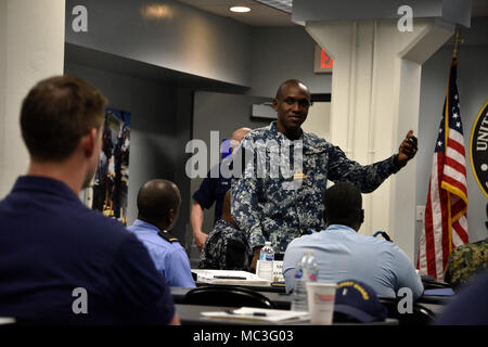 La Force de défense de la Jamaïque le lieutenant J.G. Christopher Gowey se présente au personnel militaire participant à l'échange d'experts en la matière au secteur de la Garde côtière de Key West, le 3 avril 2018. L'échange d'experts en la matière est un événement qui fait appel à la Garde côtière et plusieurs organismes partenaires internationaux partagent leurs connaissances sur l'entretien des actifs de surface. Banque D'Images