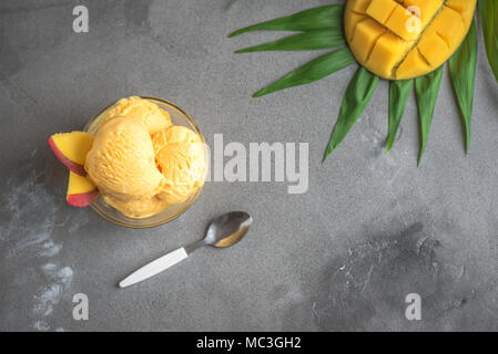 Glace ou d'un sorbet de mangue dans un bol. La crème glacée mangue fruits maison, vue du dessus, copiez l'espace. Banque D'Images