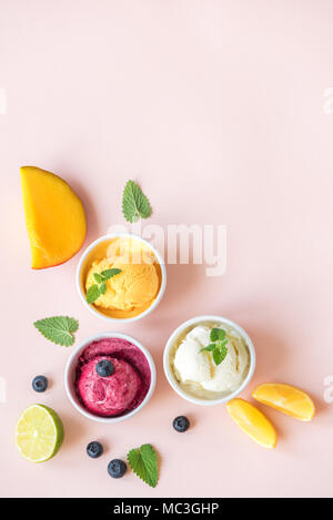 Trois différents fruits et baies des glaces sur fond rose, copiez l'espace. Le yogourt glacé ou une glace au citron, mangue, les bleuets - l'été en bonne santé Banque D'Images