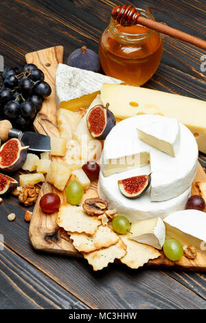 Fromage Brie sur une planche en bois avec des figues fraîches et des raisins Banque D'Images