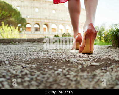 Petit coup de pieds femelles dans d'élégantes chaussures marche sur alley avec Coliseum sur arrière-plan. Banque D'Images