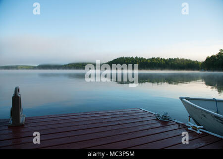 Un quai au bord du lac et sur un bateau de pêche du lac Ontario dans la brume matinale Banque D'Images