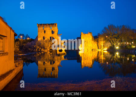 Les ruines de Borghetto sul Mincio towers le pont sur la rivière, avec l'pedestrial lane. Région Vénétie, Italie. Vue nocturne du Blue Hour. Banque D'Images