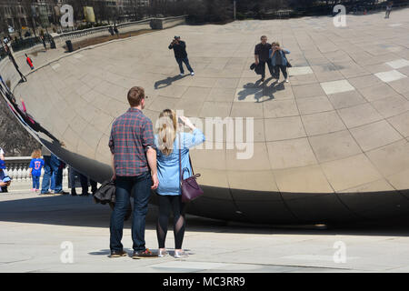 Un jeune couple de poser pour vos autoportraits avec Chicago's 'Bean' dans le Parc du millénaire par une chaude journée de printemps. Banque D'Images