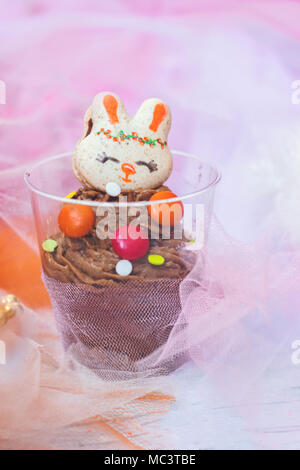 Mousse au chocolat en plastique transparent, décoré de biscuit en forme de lapin Banque D'Images