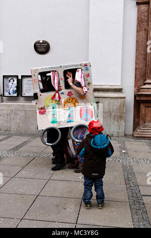 Enfant regardant les hommes dans une boîte de hippie, Fasching street party, Munich, Haute-Bavière, Allemagne, Europe Banque D'Images