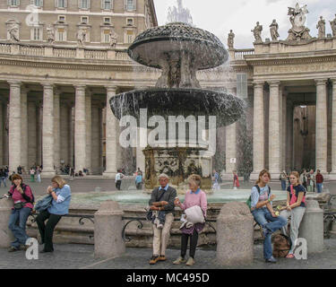 Rome, Italie. 14Th Oct, 2004. Les touristes reste à côté de l'une des deux fontaines Renaissance sur la Place Saint-Pierre (Piazza San Pietro) (Forum Sancti Petri), une grande place publique en face de la Basilique Papale de Saint Pierre dans la Cité du Vatican à Rome, une destination touristique populaire et de pèlerinage. Credit : Arnold Drapkin/ZUMA/Alamy Fil Live News Banque D'Images