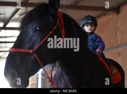 Un enfant à cheval au cours de la thérapie assistée par les chevaux (manger) dans Stritez, République tchèque, le 11 avril 2018. Le Dorado Civic Society aide les enfants handicapés pendant 25 ans. (CTK Photo/Lubos Pavlicek) Banque D'Images