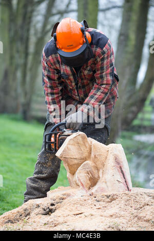 Kidderminster, UK. 13 avril, 2018. Météo France : après tant de pluie persistante hier, aujourd'hui, pause bienvenue permet effectivement ce sculpteur sur bois à poursuivre son occupation quotidienne. Bien que plutôt humide, il est encore capable de travailler, in situ, avec la matière première, sur son dernier projet dans ce parc public dans le Worcestershire. Cette commission est destinée à devenir une grenouille - un sujet parfait pour de telles l'humidité, mauvais temps. Credit : Lee Hudson/Alamy Live News Banque D'Images