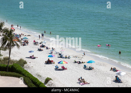 Vue de dessus de la scène de plage le long de la côte de Floride à Naples. Les familles en vacances sur les vacances de printemps. Parasols colorés.