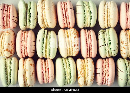 Macarons colorés télévision française. Couleurs pastel rose, vert, jaune macarons with copy space, vue du dessus. Fêtes et célébrations concept. Sweet cadeau pour femme, jeune fille Banque D'Images