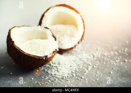 Les moitiés de noix de coco Coconut fuit avec copeaux sur fond de béton gris. Copyspace Banque D'Images