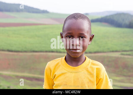 Lugazi, en Ouganda. 18 juin 2017. Smiling garçons ougandais debout sur le sommet d'une montagne au-dessus les régions rurales de l'Ouganda. Banque D'Images