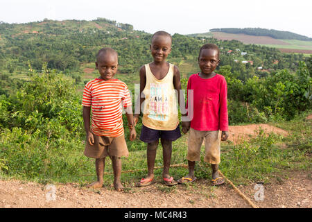 Lugazi, en Ouganda. 18 juin 2017. Smiling garçons ougandais debout sur le sommet d'une montagne au-dessus les régions rurales de l'Ouganda. Banque D'Images