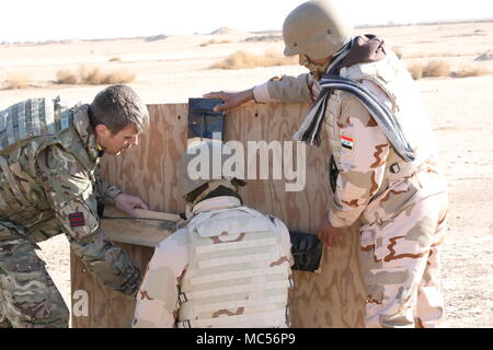 Un ingénieur de l'armée britannique et des soldats de la 38e brigade de l'armée irakienne montent des dispositifs explosifs de rupture sur une porte simulée en contreplaqué lors d'un cours d'assaut de démolition au complexe de Besmaya Range, en Irak, le 29 janvier 2018, soutenant les opérations de la Coalition contre l'Etat islamique. L'image d'archive enregistre des instructions pratiques de brèche urbaine. Banque D'Images
