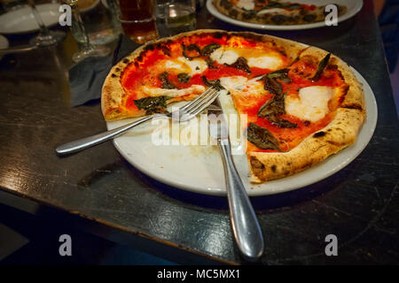 Une tranche de ce manque dans une pizza Margherita cuite dans un four à bois. Banque D'Images