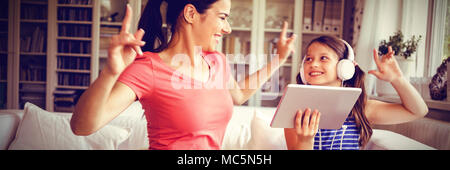 Happy mother and daughter using digital tablet et danse Banque D'Images