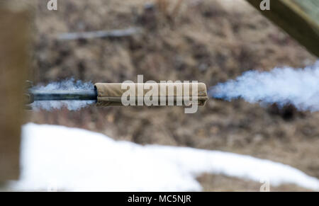 Le gaz s'échappe du canon d'un fusil de précision M2010 l'amélioration en tant que parachutiste affecté à la 1ère Escadrille, 40e Régiment de cavalerie (Airborne), 4th Infantry Brigade Combat Team (Airborne), 25e Division d'infanterie de l'armée américaine, l'Alaska, feux à une cible à distance sur une base commune à la gamme Statler Elmendorf-Richardson, Alaska, 6 avril 2018, au cours d'entraînement. Un sniper est la principale responsabilité d'offrir une très grande précision, discriminatoires contre des fusils des cibles ennemies qui ne peuvent pas être engagés avec succès par le carabinier ordinaire en raison de l'éventail, la taille, l'emplacement, la nature fugace, ou la visibilité. Banque D'Images