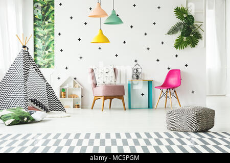 Tipi noir et blanc placé à l'intérieur de jeux bien colorés avec des lampes et wallpaper Banque D'Images