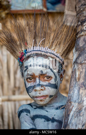 Portrait d'un jeune garçon avec peinture sur corps et une coiffure de plumes de casoar, zone Goroka, Eastern Highlands Province, Papouasie Nouvelle Guinée Banque D'Images