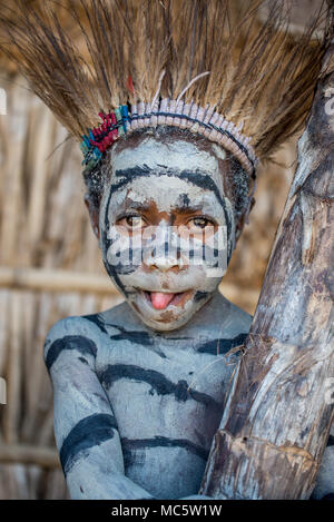 Portrait d'un jeune garçon avec peinture sur corps et une coiffure de plumes de casoar, zone Goroka, Eastern Highlands Province, Papouasie Nouvelle Guinée Banque D'Images