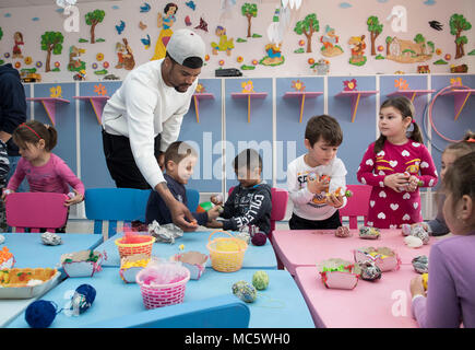 DEVESELU, Roumanie (28 mars 2018) Master-at-Arms 3 classe Gregory Coupe, affecté à l'installation de soutien naval Deveselu, aide les enfants à partir de Deveselu School, une école roumaine locale, trouver des oeufs de Pâques au cours d'une les relations communautaires (COMREL) projet. NSF Deveselu AAMDS et Roumanie sont situés dans la base militaire roumaine 99e et jouer un rôle clé dans la défense antimissile balistique en Europe orientale. Banque D'Images