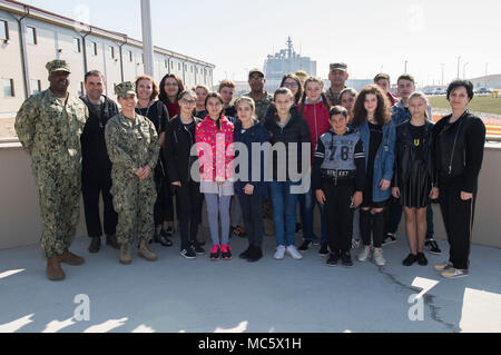 Roumanie (30 mars 2018) Capt Charlos Washington, commandant du Centre affectés à l'installation de soutien naval Deveselu, et le Colonel Razvan Bratulesu, commandant de la base pour la 99e base militaire de Deveselu, prendre une photo de groupe avec les enseignants et les étudiants de l'école, un Deveselu école roumaine locale, au cours d'une des relations communautaires (COMREL) Projet sur base. NSF Deveselu AAMDS et Roumanie sont situés dans la base militaire roumaine 99e et jouer un rôle clé dans la défense antimissile balistique en Europe orientale. Banque D'Images