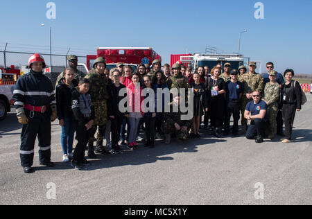 Roumanie (30 mars 2018) de marins de la facilité de soutien naval Deveselu et les soldats de la 99e base militaire roumaine prendre une photo de groupe avec les enseignants et les étudiants de l'école, un Deveselu école roumaine locale, au cours d'une des relations communautaires (COMREL) Projet sur base. NSF Deveselu AAMDS et Roumanie sont situés dans la base militaire roumaine 99e et jouer un rôle clé dans la défense antimissile balistique en Europe orientale. Banque D'Images