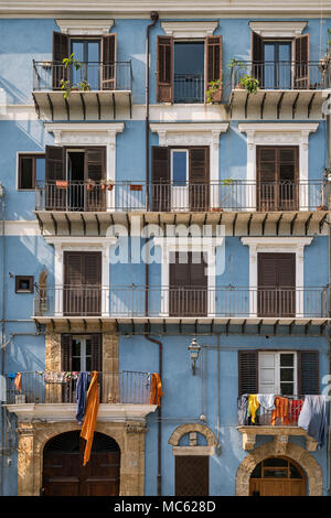 Lave-colorés suspendus sur un balcon d'un immeuble avec des murs peints en bleu à Palerme, Sicile, Italie. Banque D'Images