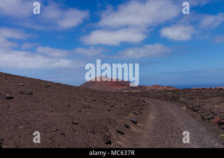 Cône volcanique dans le Parc National de Timanfaya à Lanzarote, îles Canaries. Un sentier de randonnée à travers le champ de lave et paysage Banque D'Images