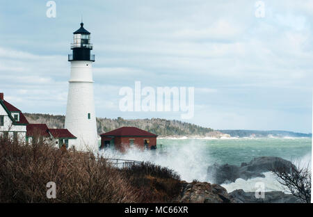 De hautes vagues des grandes marées astronomiques rares se briser sur les rochers par le phare de Portland dans le Maine. Banque D'Images