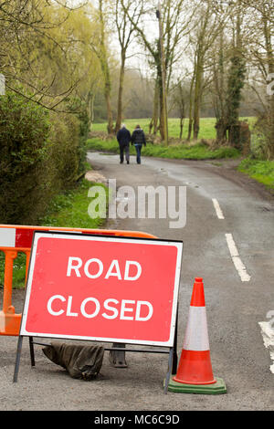 Une route fermée temporairement en raison de fortes pluies qui a fait un point plus unpassable Fording River sur des deux personnes à pied. Dorset England Uk Banque D'Images