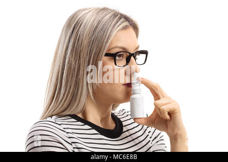 Jeune femme à l'aide d'un spray nasal isolé sur fond blanc Banque D'Images