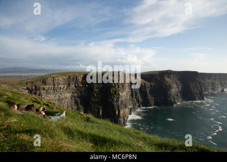 Jeune couple et admirez la vue sur les falaises de Moher, comté de Clare, Irlande Banque D'Images