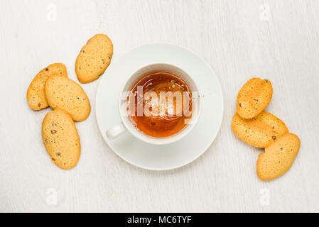 Tasse à thé d'éclaboussures sur le tableau blanc avec les cookies Banque D'Images