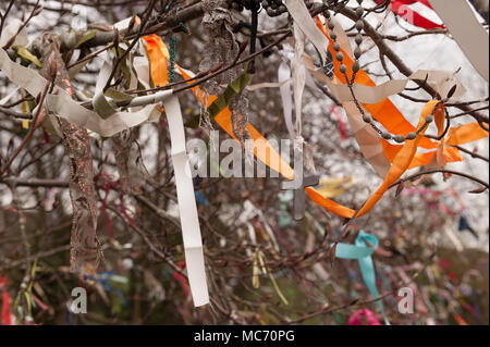 Lumineux colorés bunting, rubans, banderoles, fixés à un vieux hêtre sacré matures à proximité d'un monument célébrant la vie néolithique, ruban correcteur Banque D'Images