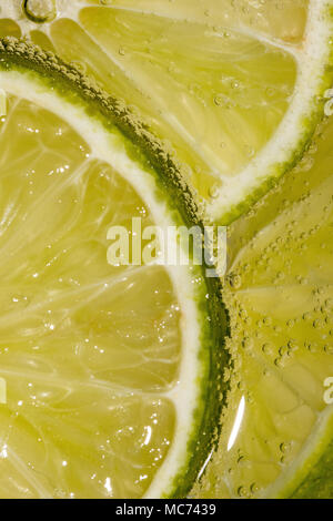 Tranches de Lime Macro dans l'eau pétillante avec bulles Banque D'Images