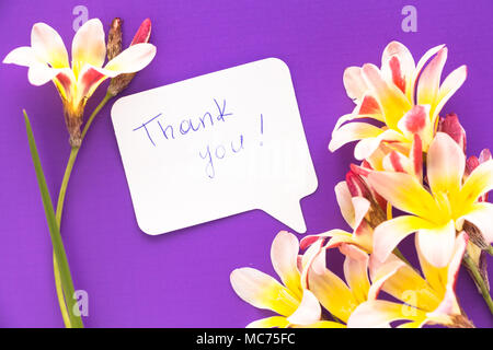 Remarque en forme de coeur avec des mots "merci !" avec des fleurs sur la surface. Banque D'Images