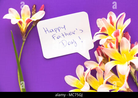 Remarque en forme de coeur avec les mots 'Happy Father's Day !' avec des fleurs pourpre sur la surface. Banque D'Images