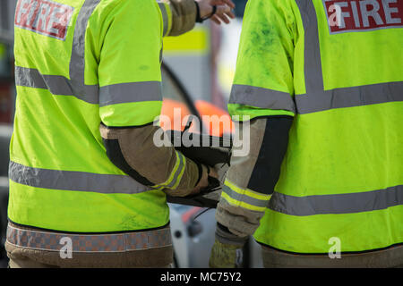 Groupe de pompiers sur le sauvetage du travail à l'aide de tablette de poche au travail Banque D'Images