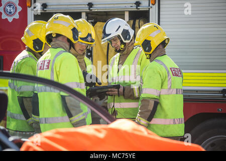 Groupe de pompiers sur le sauvetage du travail à l'aide de tablette de poche au travail Banque D'Images