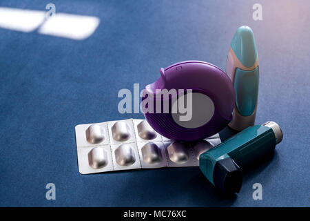 Ensemble d'asthme inhalateur, accuhaler et médicaments antiallergiques pour le traitement de l'asthme. Contrôleur de l'asthme, l'équipement de délestage sur fond bleu foncé. Bronchodi Banque D'Images