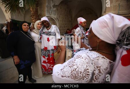 Les visiteurs de prendre des photos avec les membres de la bande, d'un femmes Deeba bande soufi de l'Océan Indien, l'île française de Mayotte, au cours de la fête de Nabi Musa, sur un site que l'on croit être la tombe de Moïse, près de la ville cisjordanienne de Jéricho, 13 avril 2018. Nabi Musa (prophète Moïse) est un 7-journée fête religieuse célébrée chaque année par les Musulmans palestiniens, centrée sur les pèlerinage de Jérusalem à ce qu'est le tombeau de Moïse. Photo : Ayman Nobani/dpa Banque D'Images